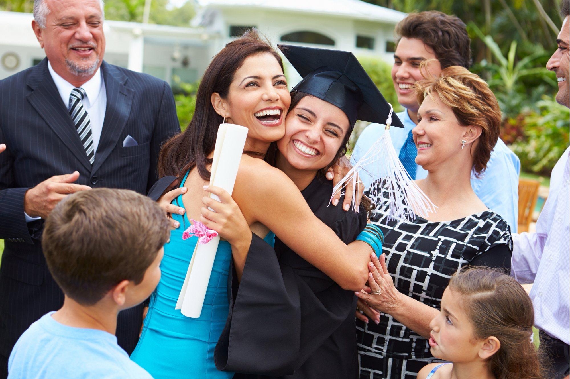 A multi-generational family celebrating and embracing their graduating daughter